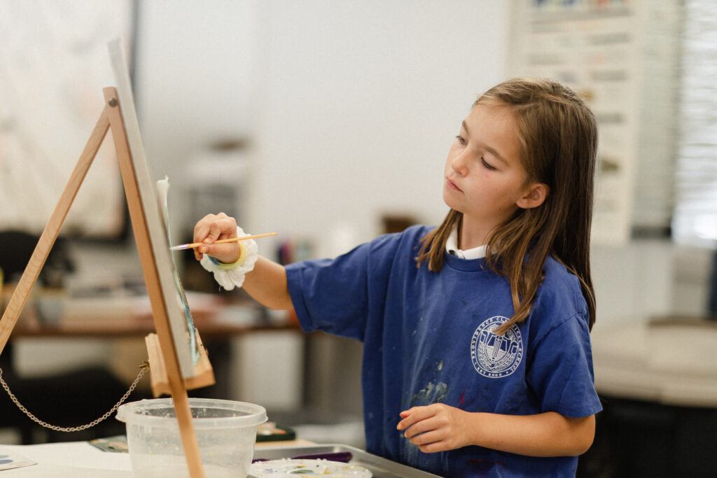 Female student painting in the art studio at Providence Classical School